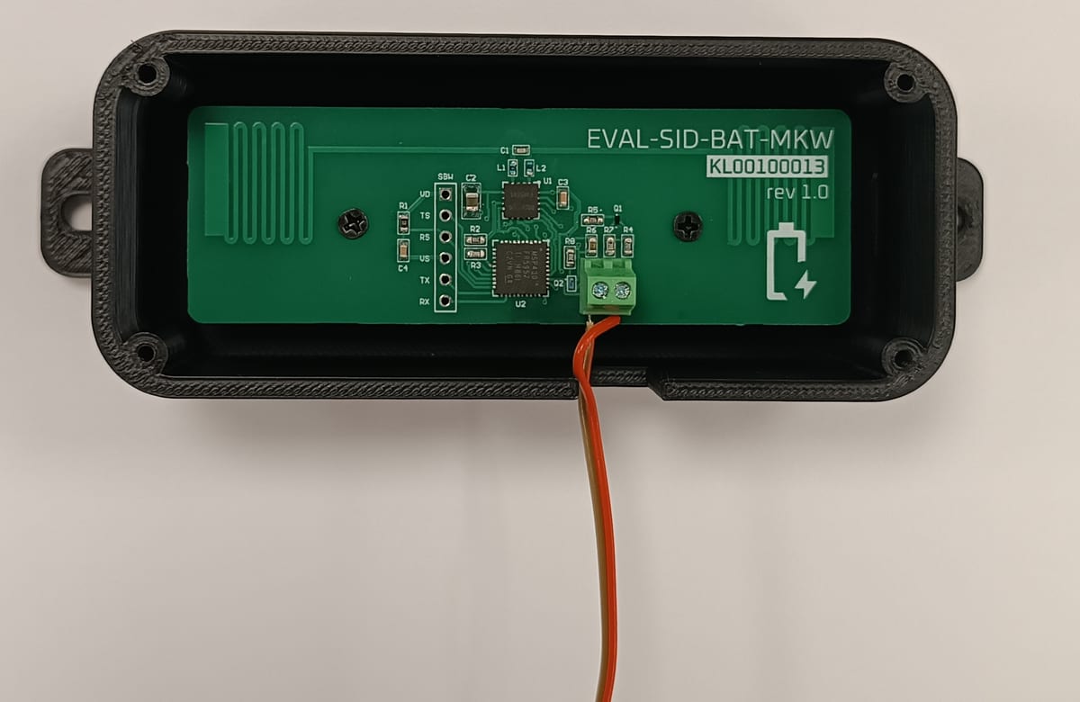 The KoBat demonstrator: the EVAL-SID-BAT-MKW board inside its printed enclosure, with the two battery wires